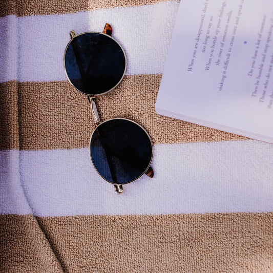 Round sunglasses on a beach towel