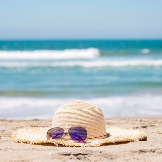 Straw sun hat and sunglasses on the beach